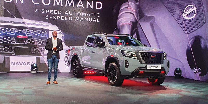 Man standing next to white Nissan Navara